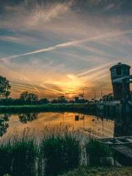 Watertoren Assendelft aan het water met gesloten brug met zonsondergang