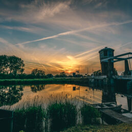 Watertoren Assendelft aan het water met gesloten brug met zonsondergang